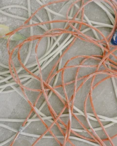 Kabel Entsorgen - schmutzige weisse und orange Kabel liegen am Boden